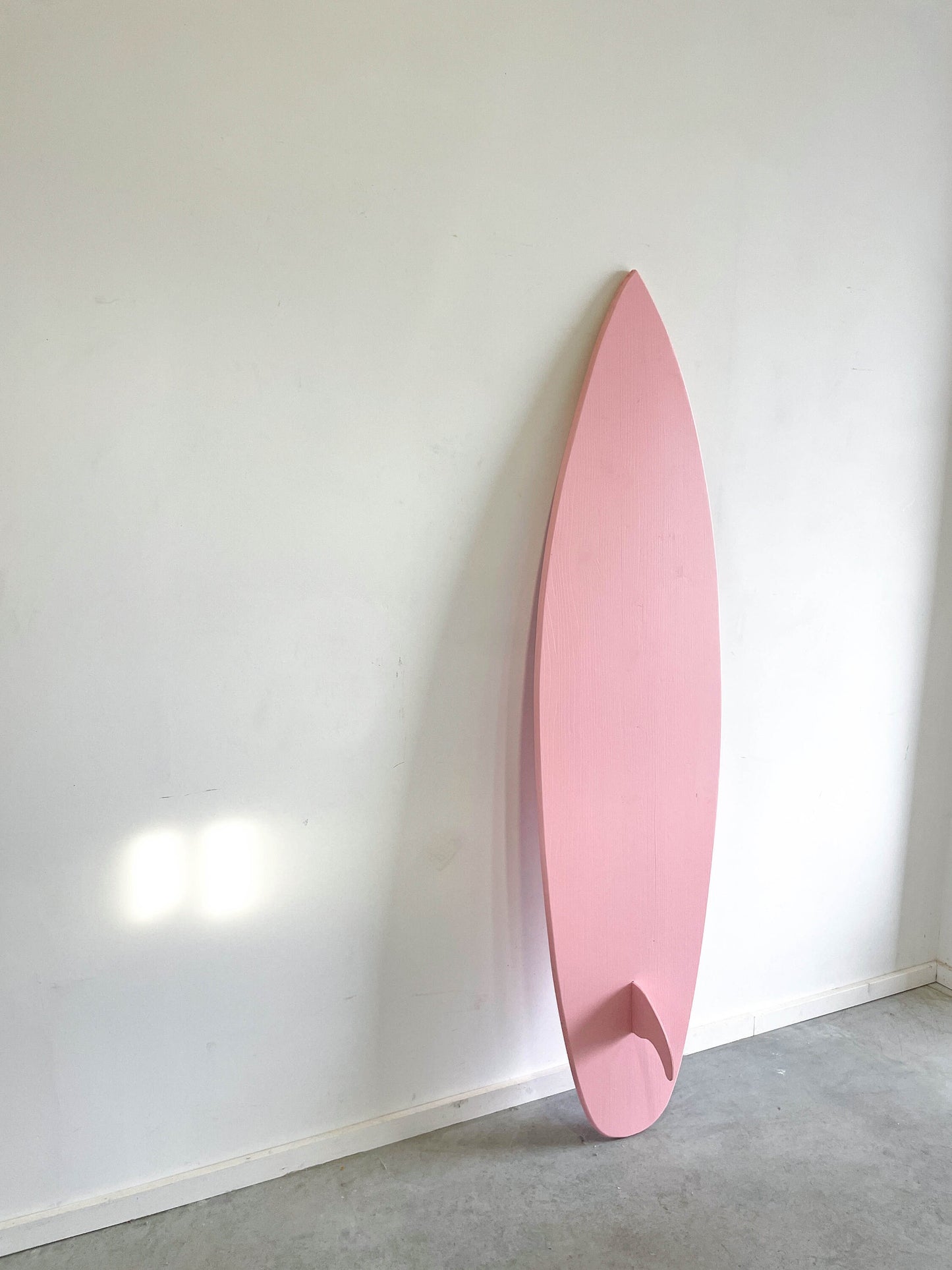 Whimsical baby pink surfboard, adding charm to your home.