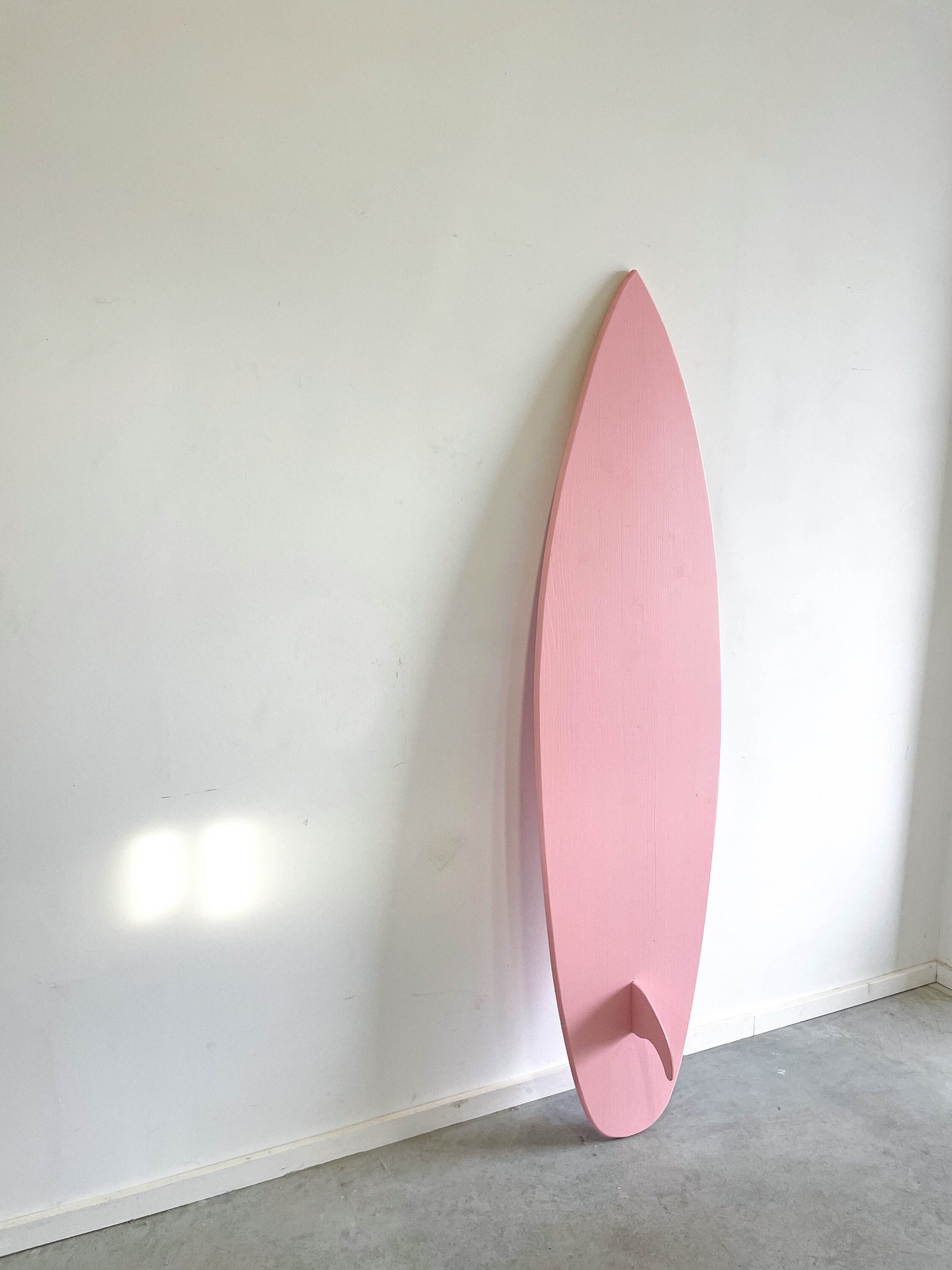 Whimsical baby pink surfboard, adding charm to your home.