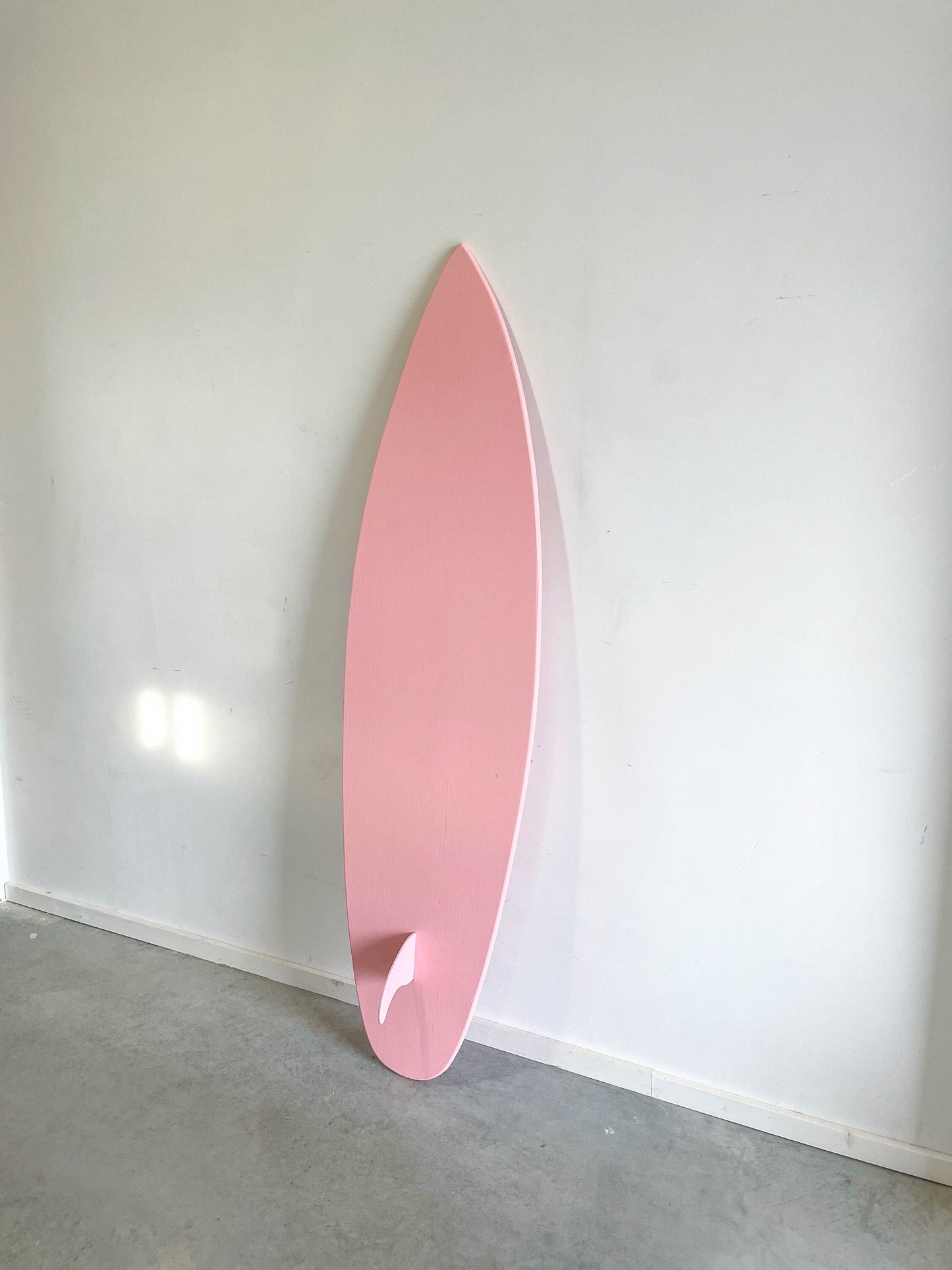 Soft-hued pink surfboard decor for stylish spaces.