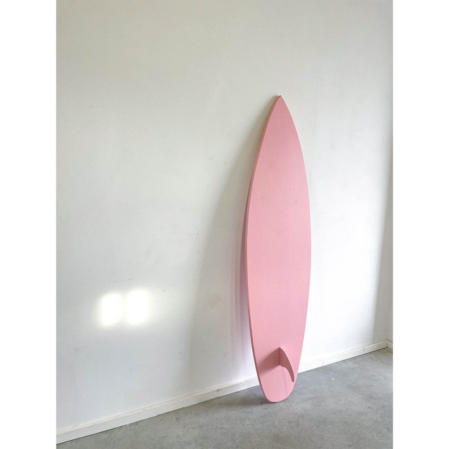 Baby pink wooden surfboard, a chic coastal accent.