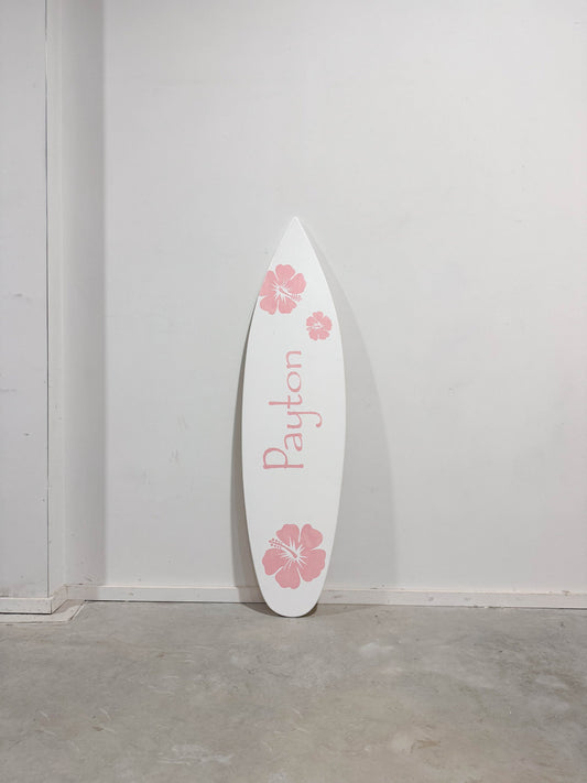 Tropical charm: White surfboard adorned with pink hibiscus flowers